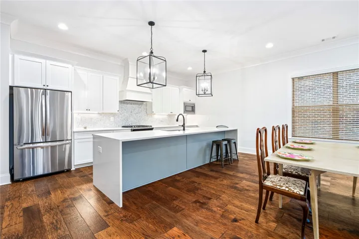The substantial kitchen island makes a statement with its quartz waterfall edge and generous seating capacity.