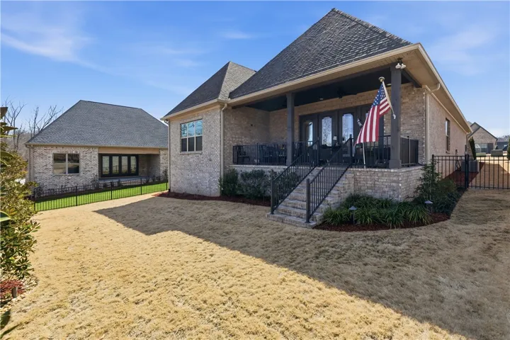 The rear façade is defined by an expansive covered porch and intentional landscape design.