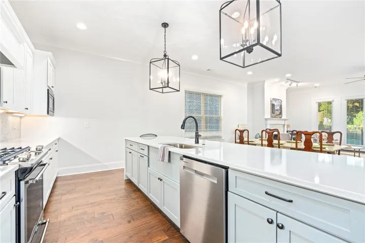 Rich hardwood floors anchor this light-filled kitchen featuring a large central island and clean modern lines.