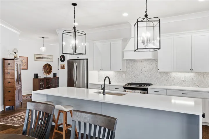The angled entry into the kitchen creates natural opportunities for thoughtful furniture placement, adding depth to the crisp, light-filled space.