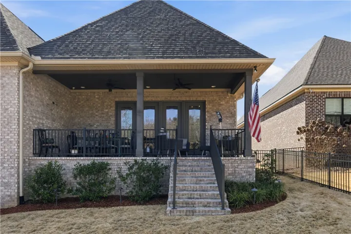 The yard, enclosed by a decorative aluminum fence, is thoughtfully landscaped.