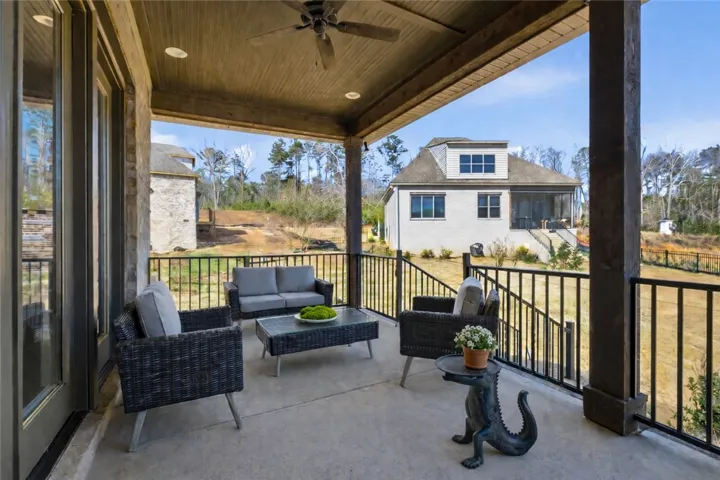 The rear porch offers generous space for multiple seating arrangements, while the four-panel door system creates a strong connection between indoor and outdoor living.