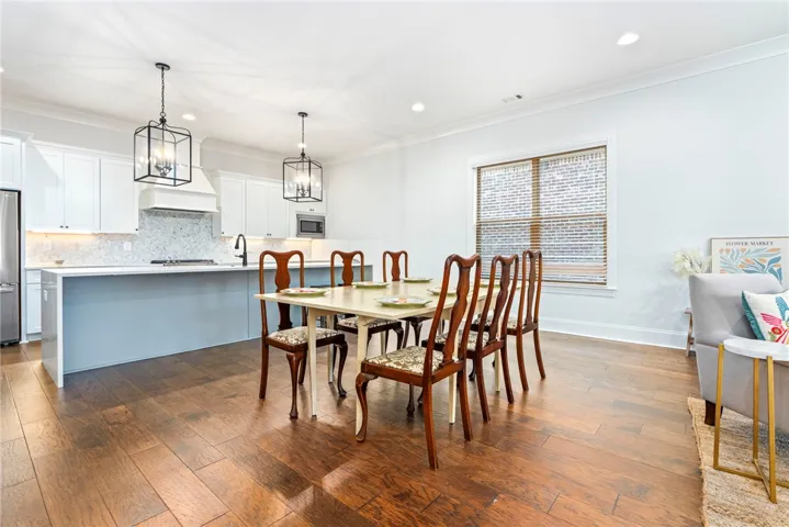 Gleaming hardwood floors and classic crown moldings enhance this open-concept culinary and dining environment.