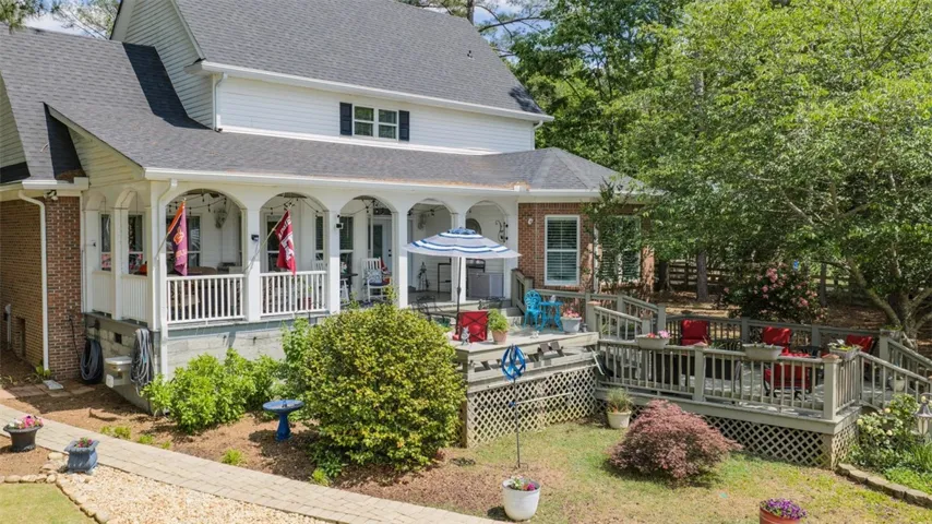This charming residence features a spacious porch and deck, perfect for outdoor relaxation and entertaining.