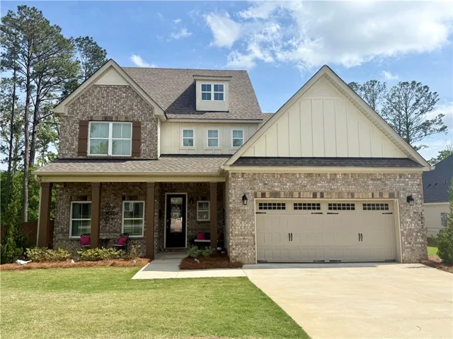 A classic brick exterior with a welcoming covered porch creates inviting curb appeal.