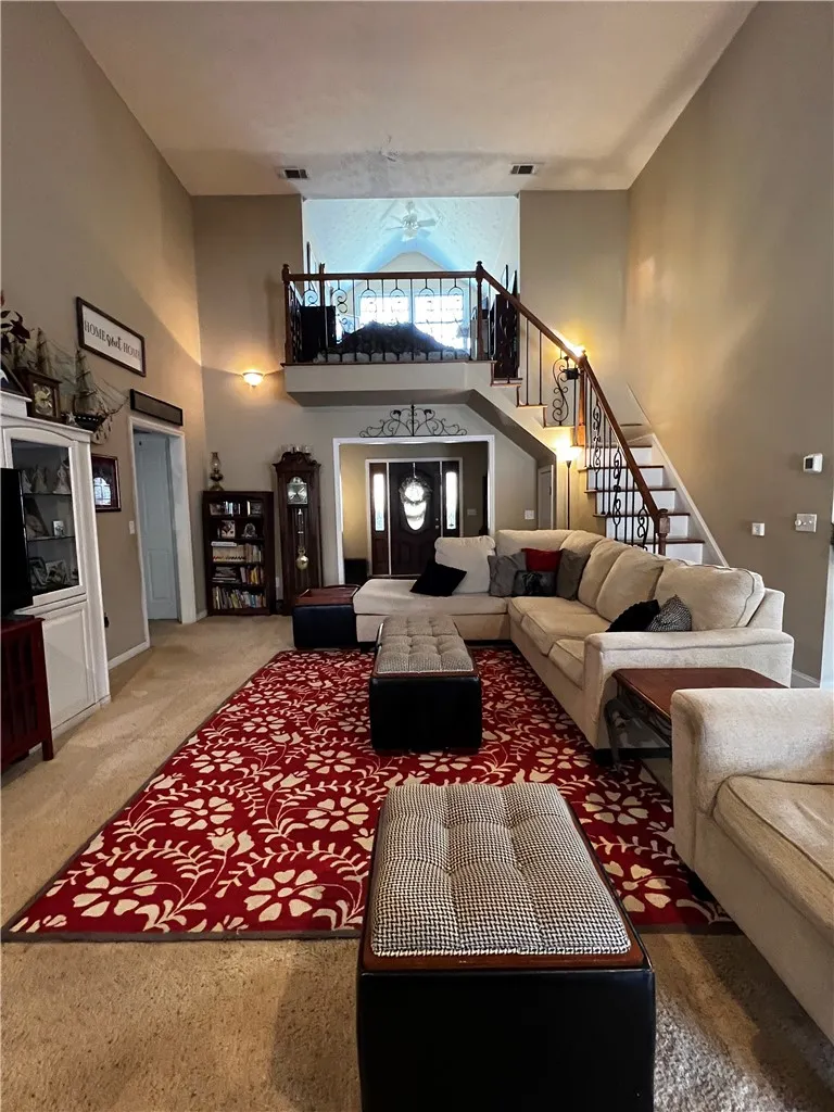 A grand living space welcomes with soaring ceilings and a stately staircase.