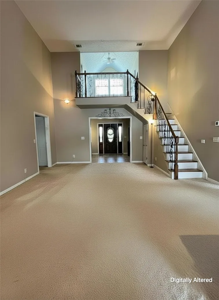 A grand two-story entryway offers a sweeping staircase and a lofty overhead landing.
Note: Photo has been digitally altered to showcase an empty space