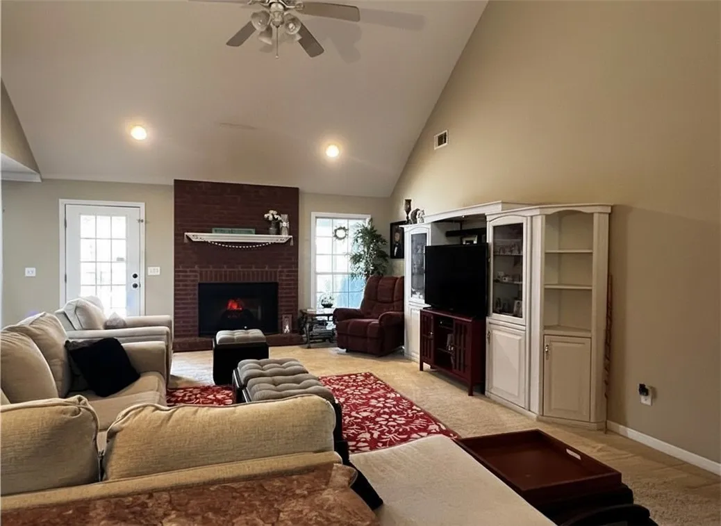 A welcoming living area showcases a cozy brick fireplace and vaulted ceilings.