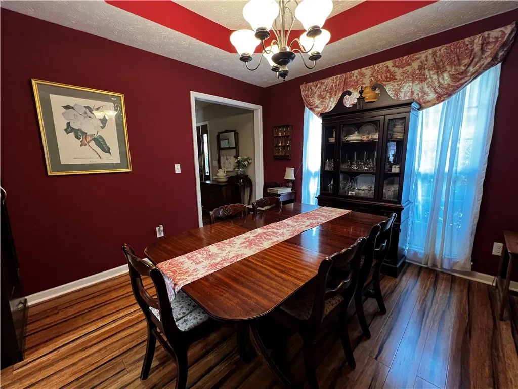 A refined dining room with rich hardwood flooring and an elegant chandelier creates a perfect setting for gatherings.