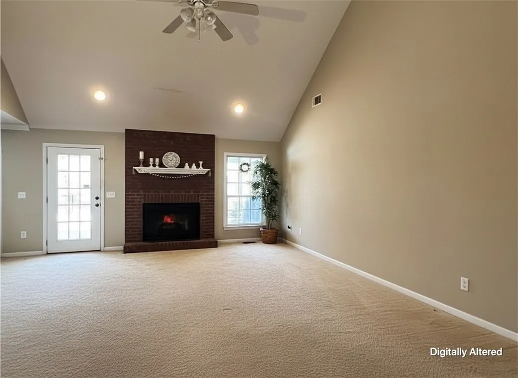 A spacious living area offers a cozy fireplace, high ceilings, and plush carpeting.
Note: Photo has been digitally altered to showcase an empty space