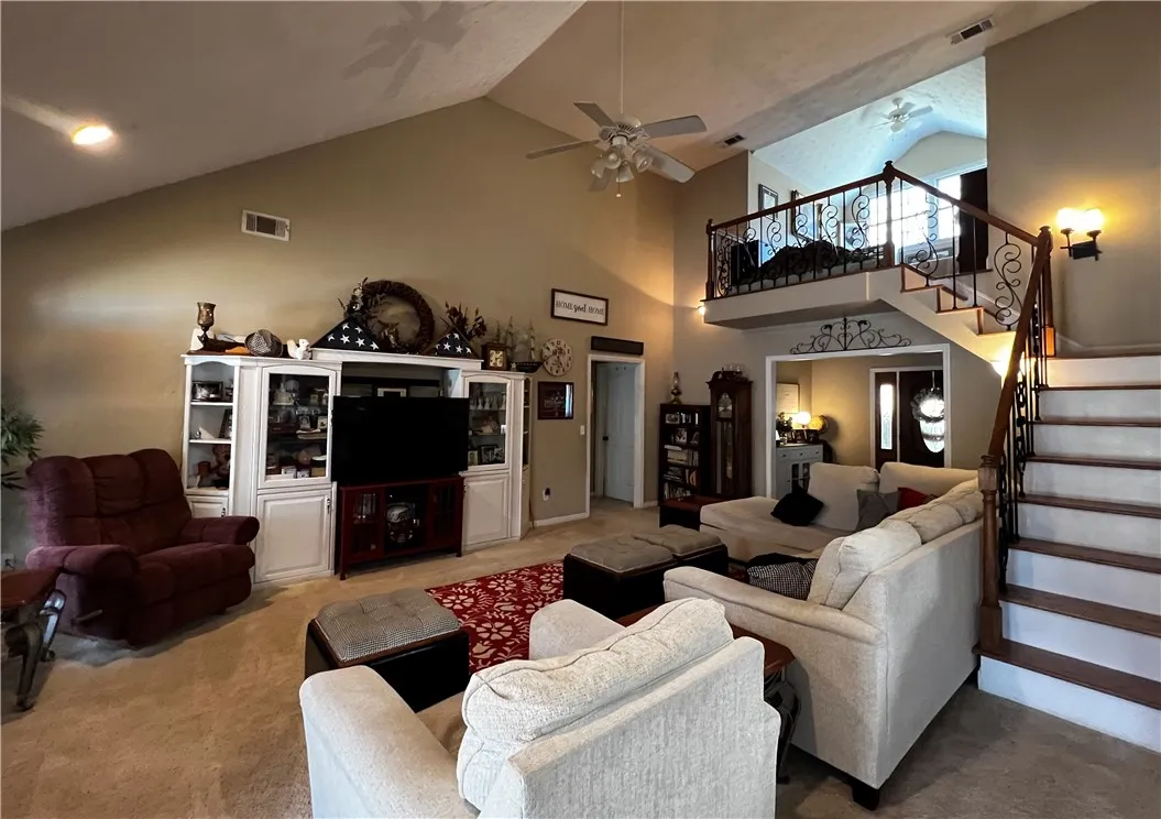 The soaring ceilings and open layout create a spacious and welcoming atmosphere in this well-lit living area.