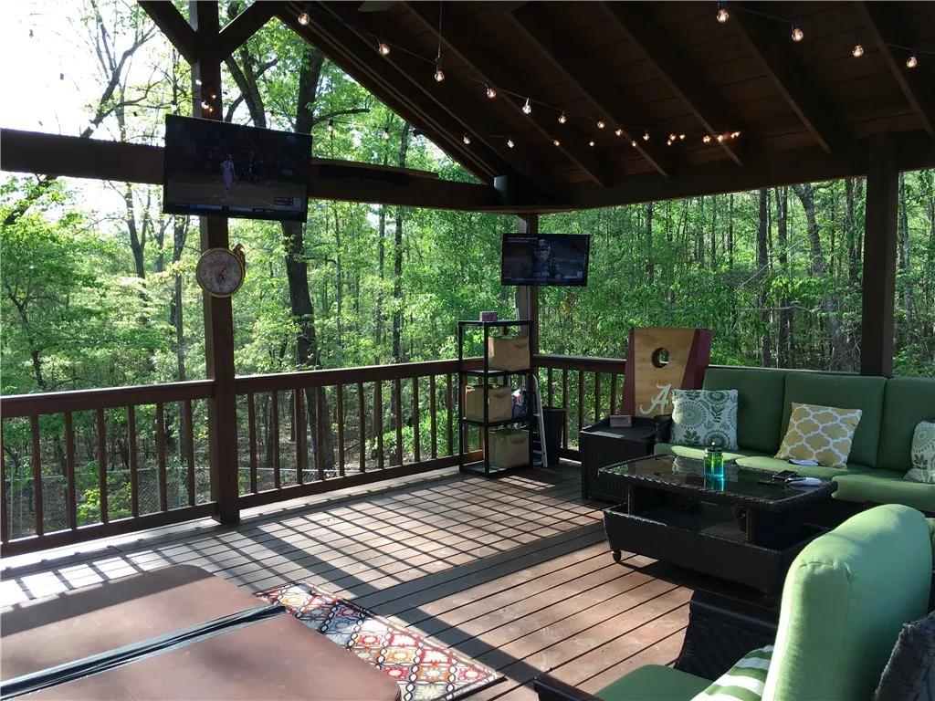 An inviting covered deck offers forest views and abundant space for outdoor living and entertainment.