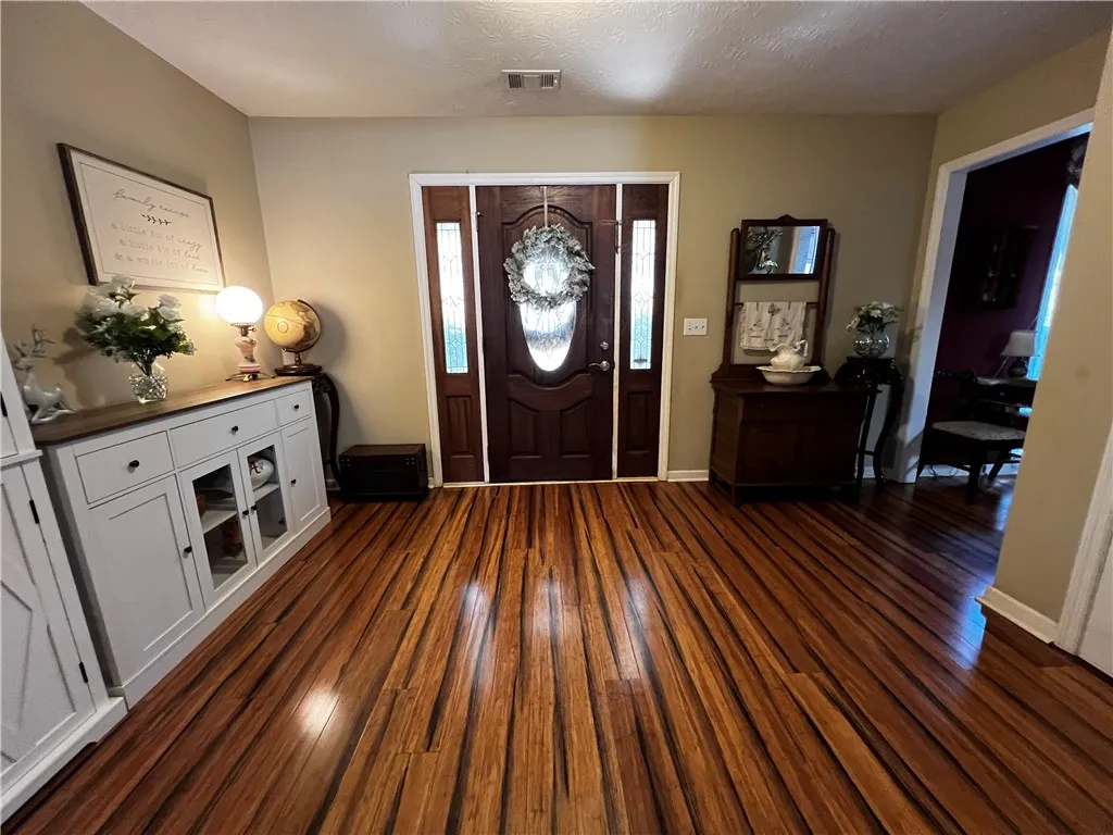 A lustrous wood entry floor and elegant front door welcome you home.