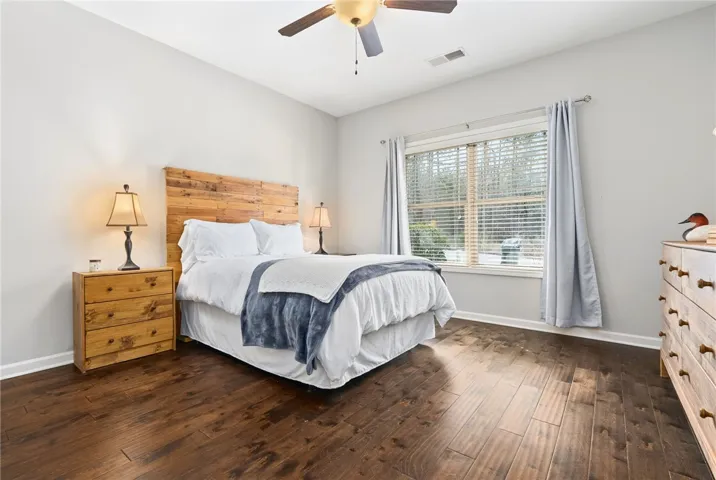 This Guest Bedroom sits on the front of the house and has lovely wood floors, a ceiling fan, and an adjoining Full Bathroom.