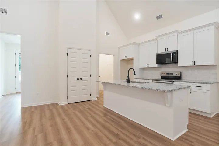 Culinary aspirations find a home in this bright kitchen, complete with a granite island and soaring vaulted ceilings.