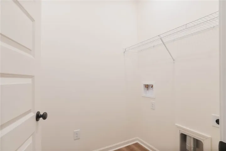 A well-organized laundry area offers a convenient wire shelving unit and hookups.