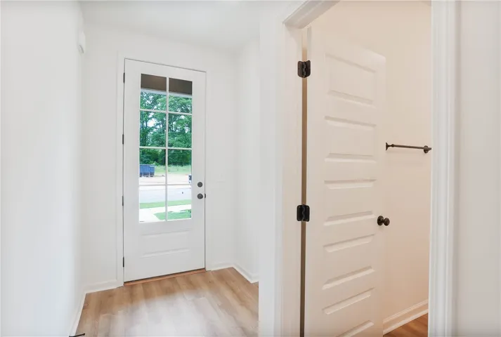 A welcoming entry features hardwood floors and a bright glass-paneled front door.