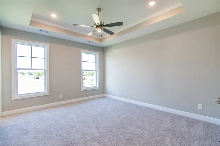 This spacious room features ample natural light and a stylish ceiling design.
