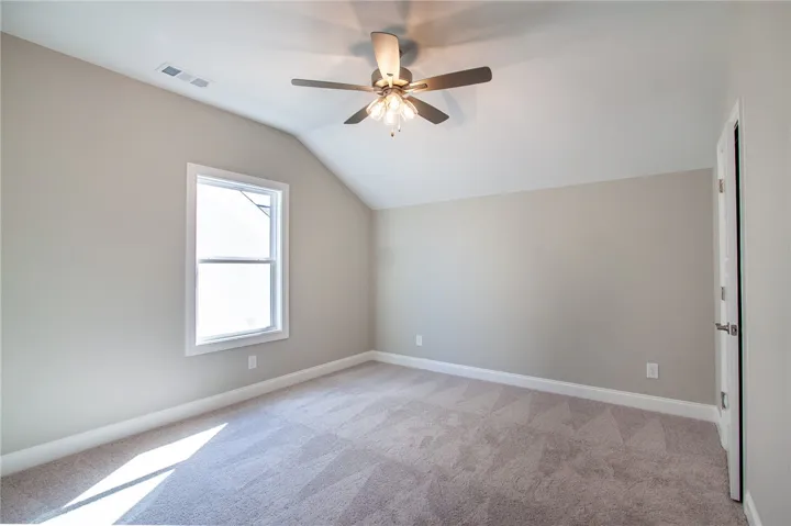 This spacious bedroom offers ample natural light and a comfortable atmosphere for rest and relaxation.