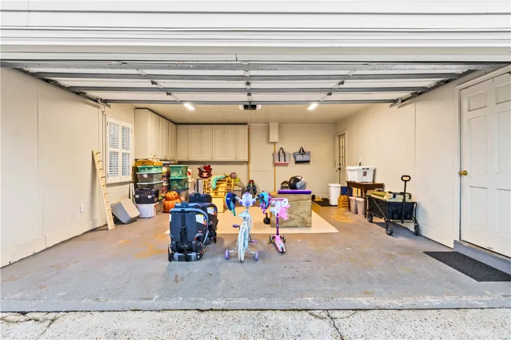 Garage with more built in cabinets & storage closet perfect for yard tools, etc.