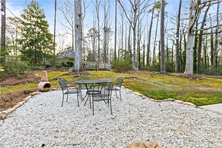 Fantastic gravel patio space recently added...planter pots/posts, string lights & swing set can remain.