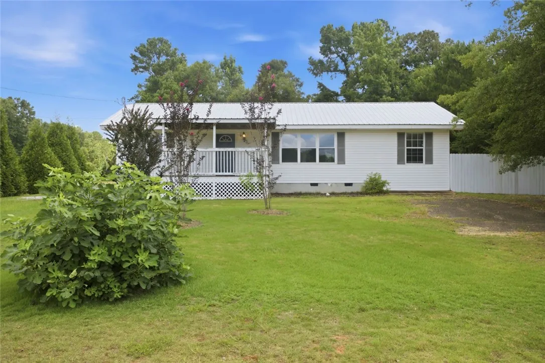 A classic ranch home nestled among abundant greenery with a welcoming front porch.