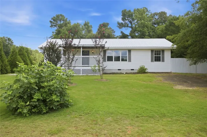 A classic ranch home nestled among abundant greenery with a welcoming front porch.