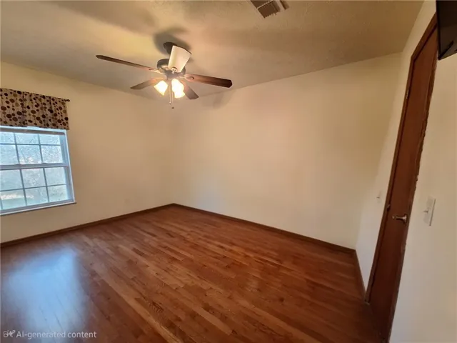 This airy room features rich hardwood flooring, creating a versatile and inviting atmosphere.