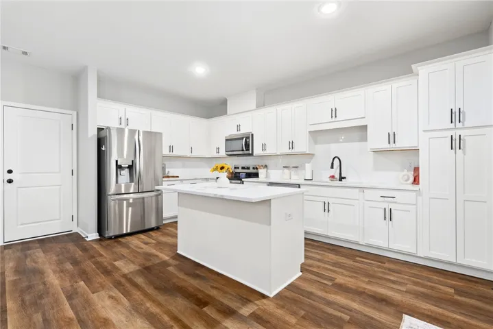 Large, open kitchen offering storage galore and eat in island!