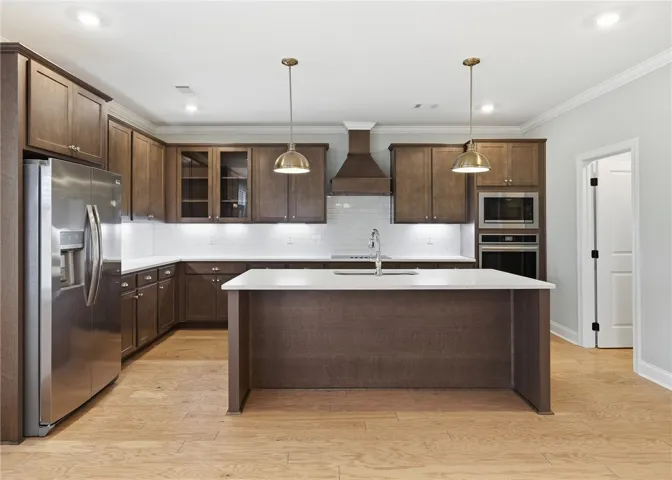 Sleek stainless appliances and chrome finishes balance the richness of the darker wood cabinetry.