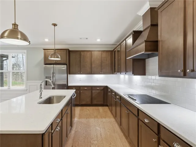 A large single-basin sink positioned opposite a sleek range creates an efficient layout for cooking.