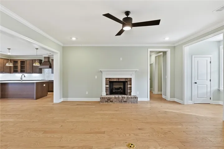 The primary suite occupies its own wing on the right side of the home (look right of the fireplace), offering separation and privacy beyond the staircase.