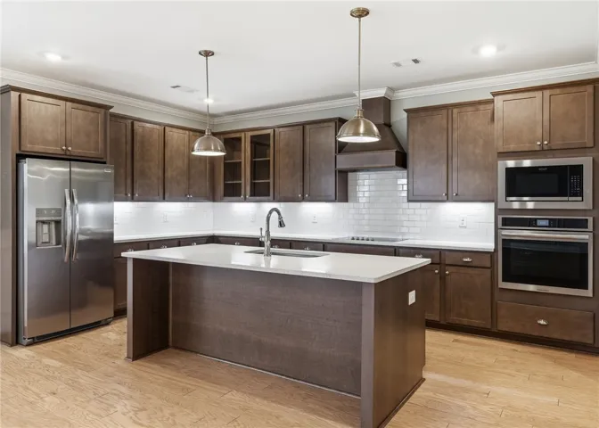 Warm wood cabinets bring depth to the kitchen, complemented by crisp white subway tile and quartz counters.