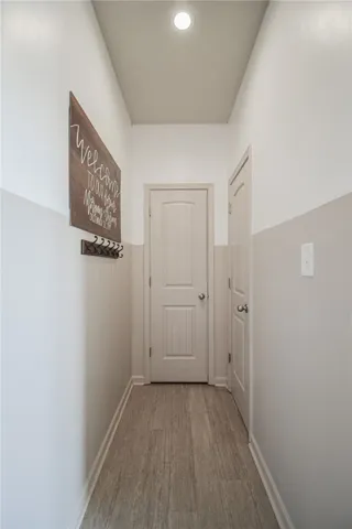 hallway to downstairs half bath and coat closet