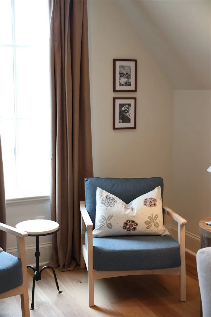 Hardwood flooring complements a cozy corner with a light-filled window, perfect for quiet contemplation.
