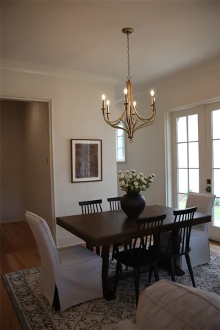 Elegant chandelier illuminates a dining area with direct access to an outdoor space.