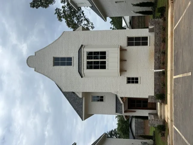 A charming facade features a distinctive gable, complemented by traditional windows and a covered entry.