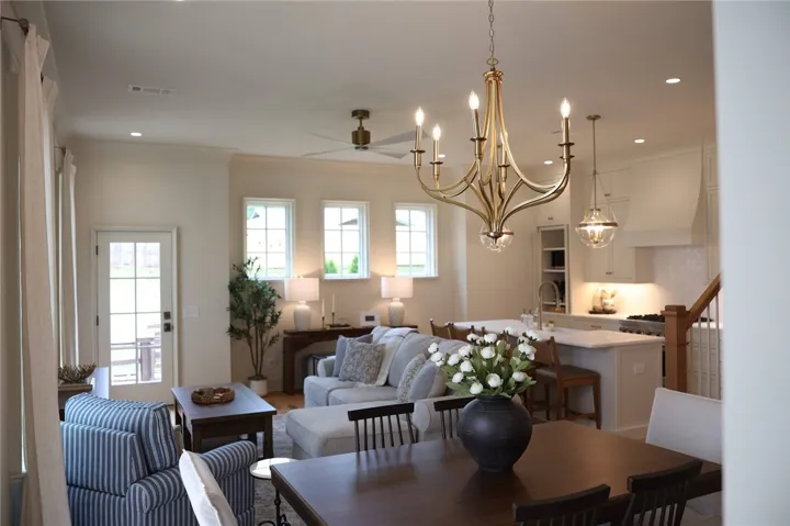An open-concept living area features a dining space, a well-appointed kitchen, and a comfortable sitting area bathed in natural light.