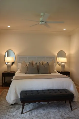 A comforting bedroom space features soft recessed lighting and a ceiling fan for optimal relaxation.