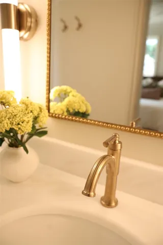 Elegant gold fixtures and a chic mirror frame elevate this well-appointed bathroom vanity.