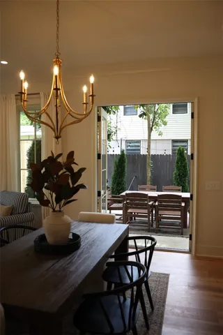 French doors open to a charming outdoor dining space with a private yard.