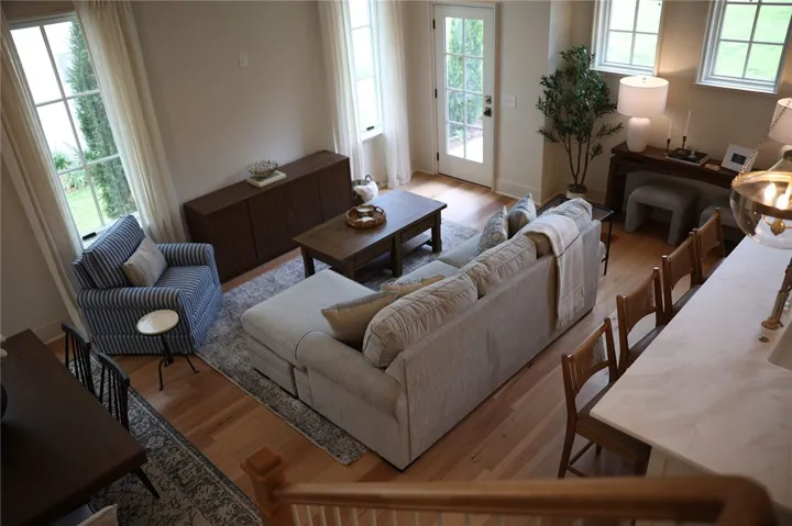 An inviting great room with gleaming hardwood floors connects living and dining spaces.