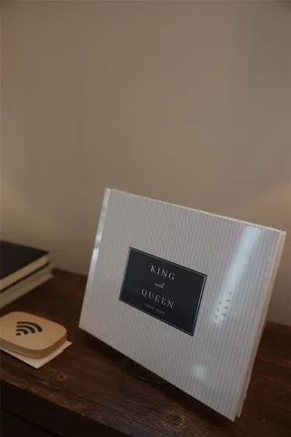 A quaint wooden side table offers a thoughtful guest book for visitors.