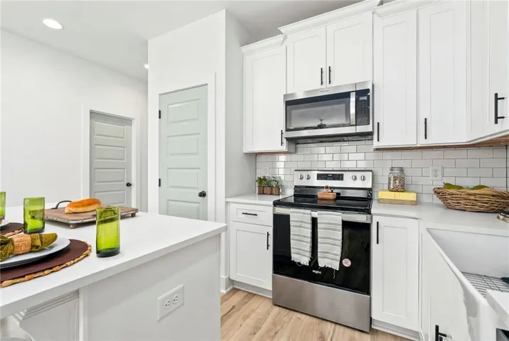 Kitchen has island offering bar seating and a pantry closet for added storage.