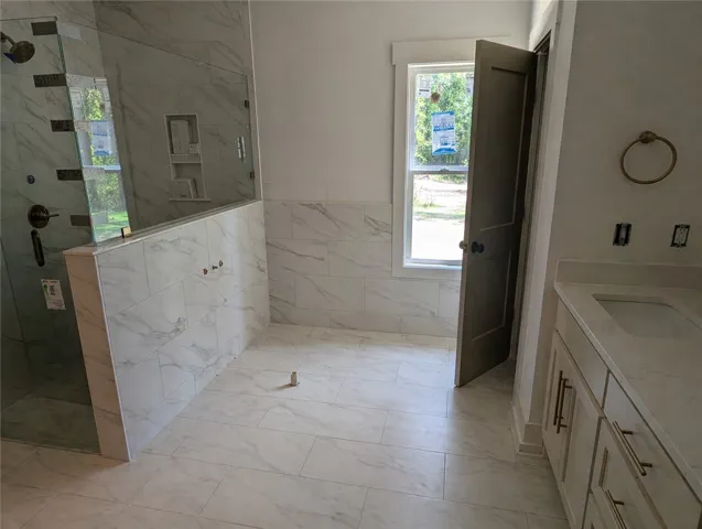 Primary bathroom with large walk in tiled shower, soaking tub & double vanity