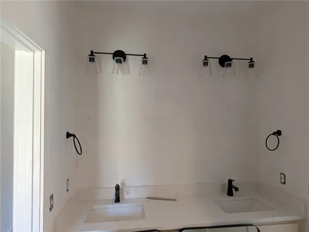 This primary bathroom offers dual sinks, contemporary fixtures, and abundant vanity space.