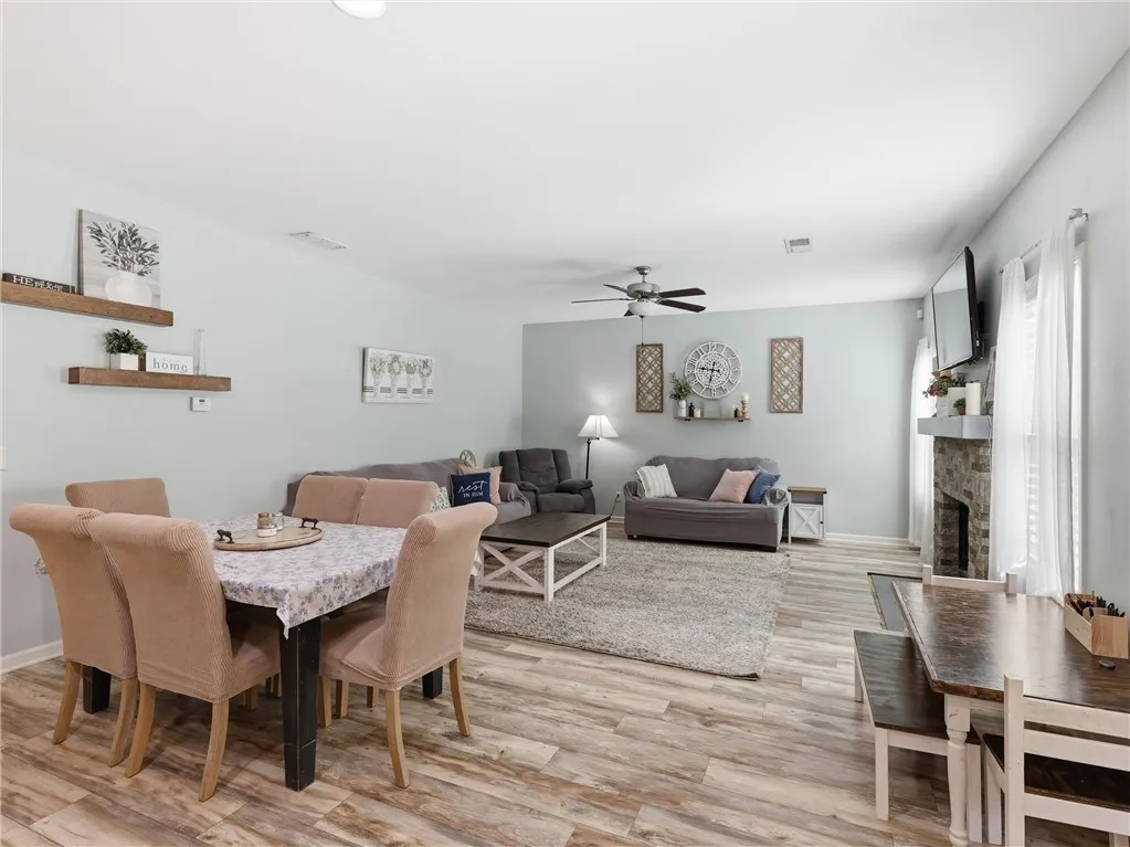 This naturally illuminated living area and dining space features durable wood-look flooring and a cozy fireplace.