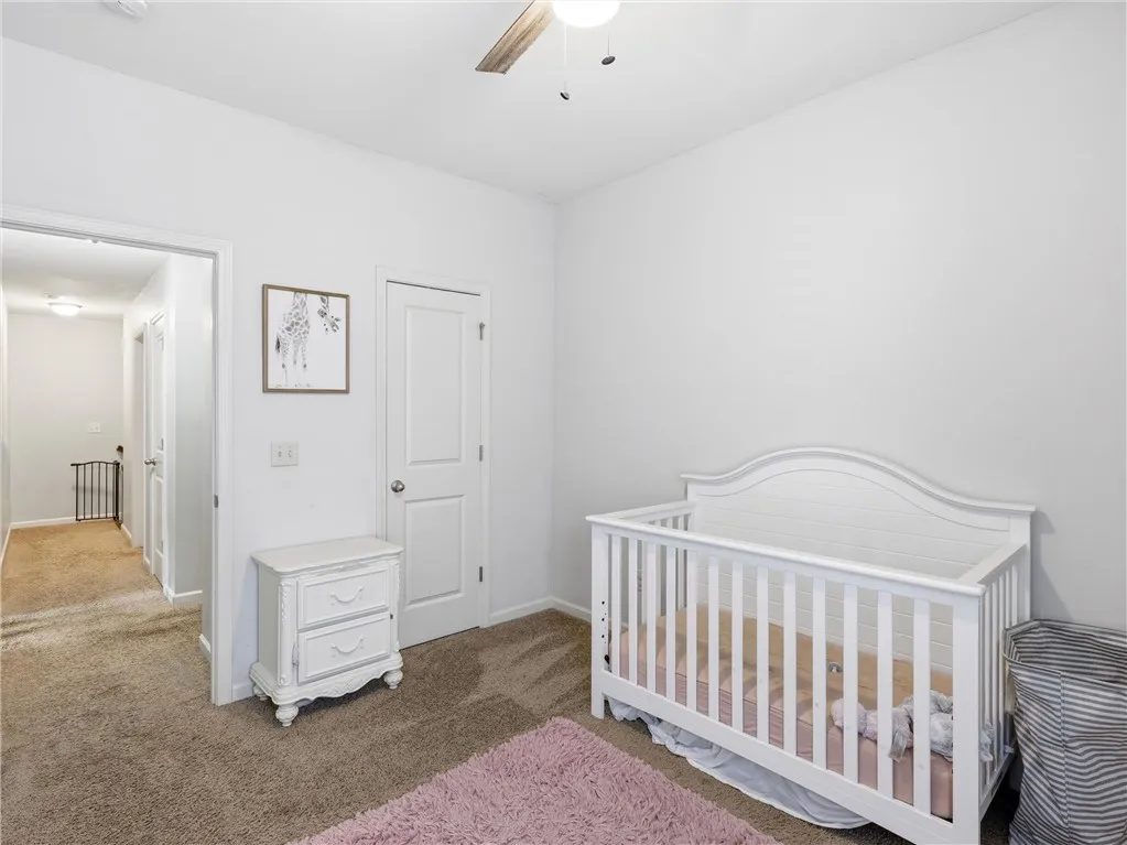 Soft carpet and clean walls define this peaceful and inviting secondary bedroom, perfect for rest.