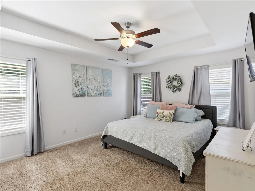 A peaceful retreat with a tray ceiling and plush carpeting.