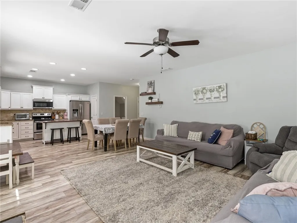 An inviting open-concept living space features a functional kitchen, dining area, and comfortable lounge.